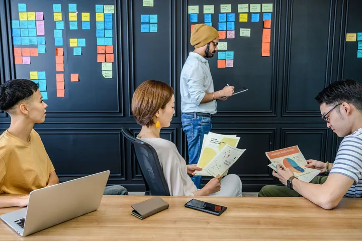 People reviewing notes and planning work around a table